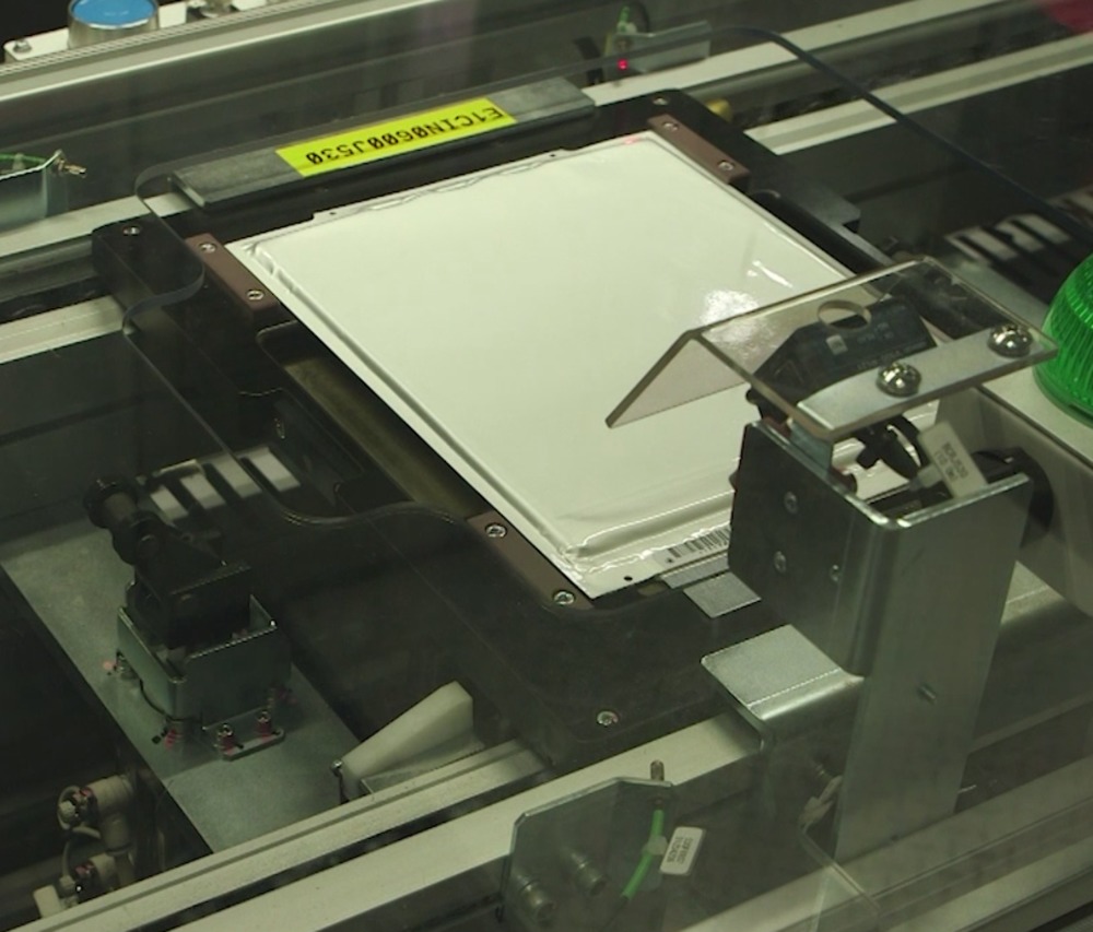 Battery cells are taken along a conveyor, with visual checks performed